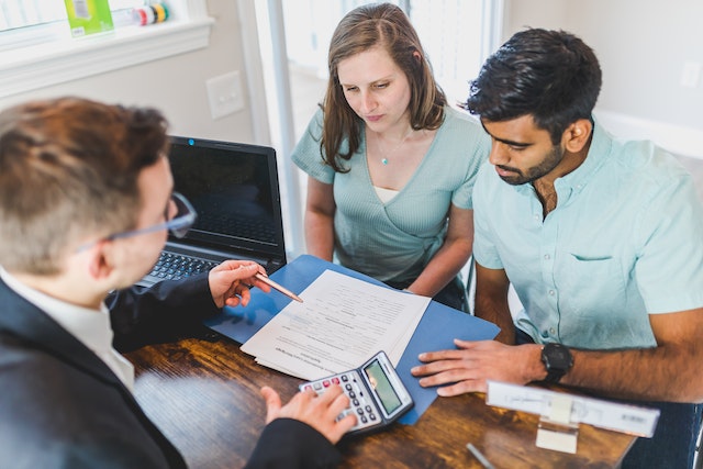 two people applying for a home mortgage and looking over the paperwork